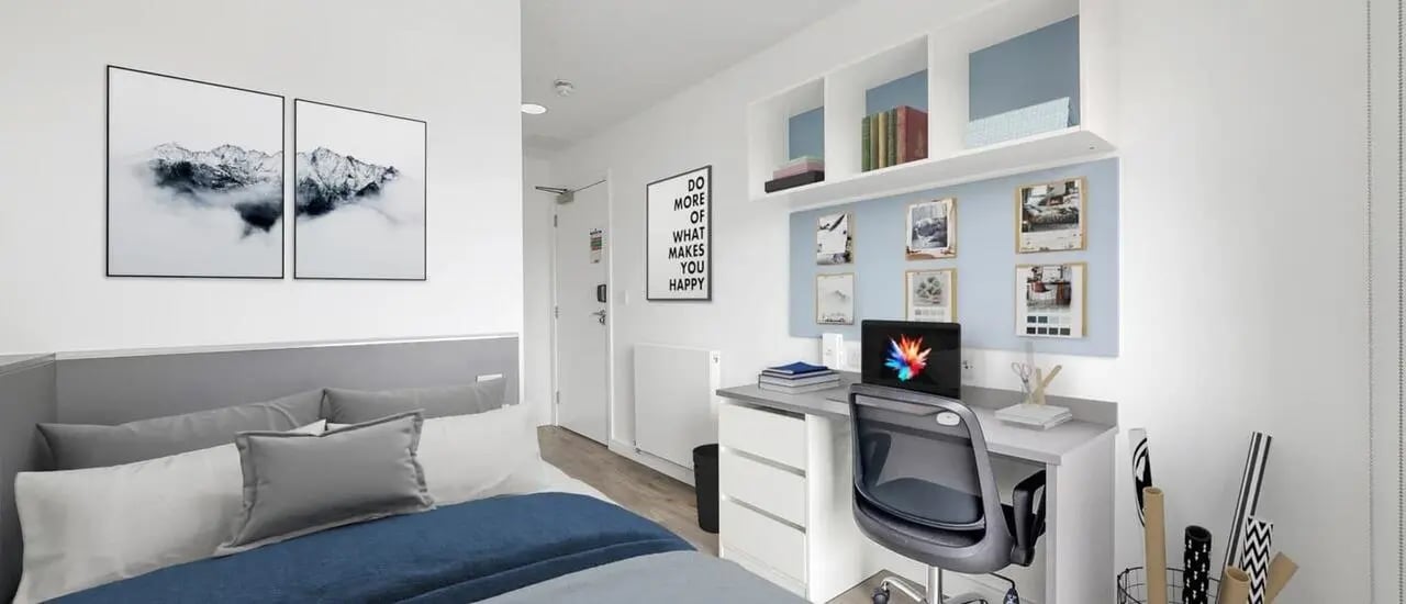 Bed with artwork desk with laptop study area at Chapter Highbury II in London Student Accommodation