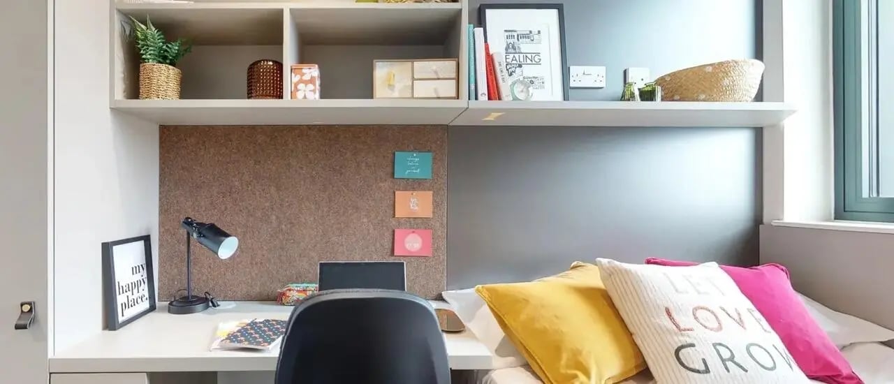 Desk lamp corkboard laptop pillows bedding bedroom at Chapter Ealing in London Student Accommodation