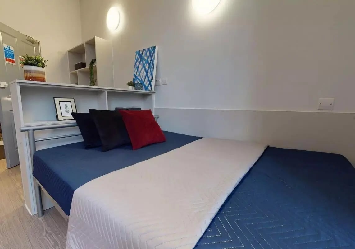 Bed with blue bedding and pillows bedroom at iQ Studios 51 in Birmingham Student Accommodation