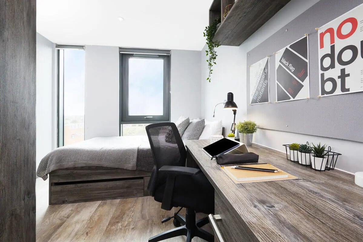 Bed desk chair tablet plants bedroom study area at Collegiate Crown Place Norwich in Norwich Student Accommodation
