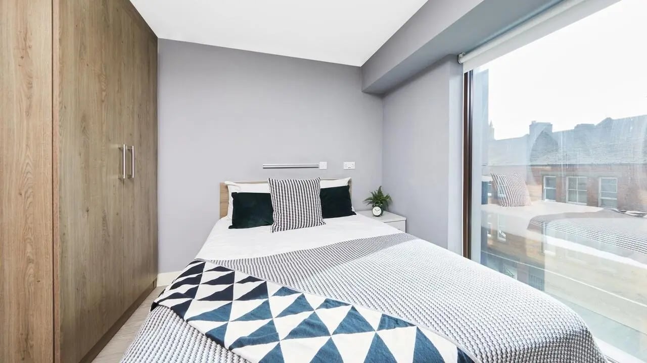 Bed with patterned throw and closet bedroom at Collegiate Nova in Nottingham Student Accommodation