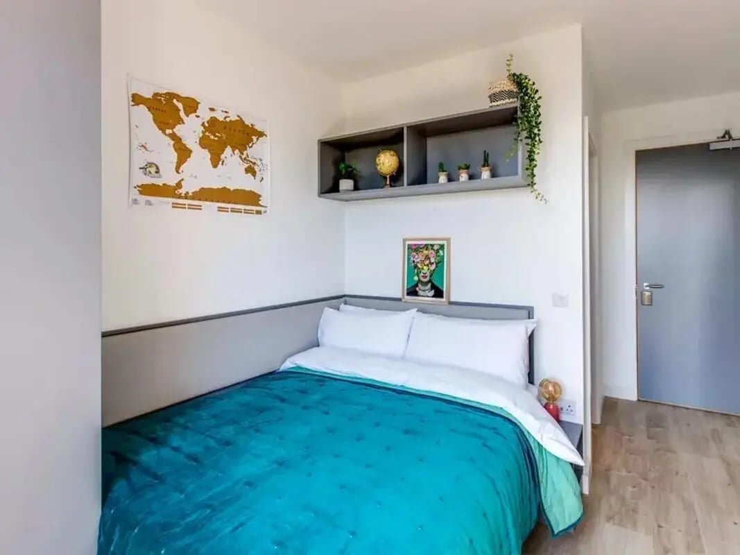 Bed with teal duvet globe map art bedroom at Lee Point in Cork Student Accommodation