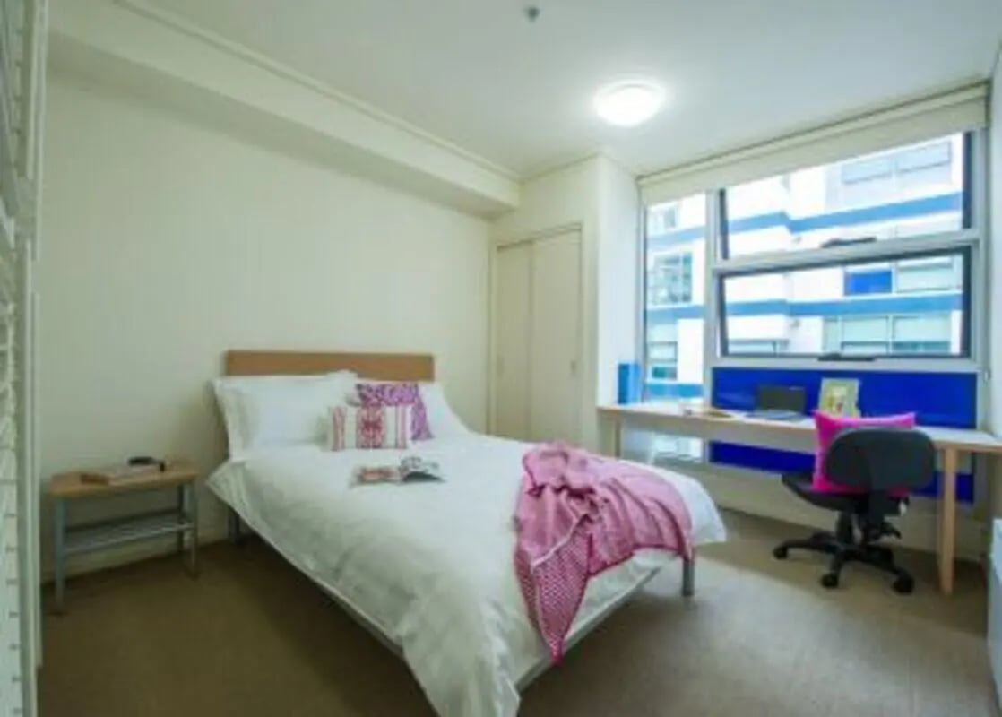 Bed desk chair and window bedroom at Student Living - 800 Swanston in Melbourne Student Accommodation
