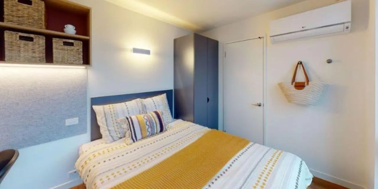 Bed with woven baskets and tote bag bedroom at UniLodge Melbourne Flagstaff in Melbourne Student Accommodation