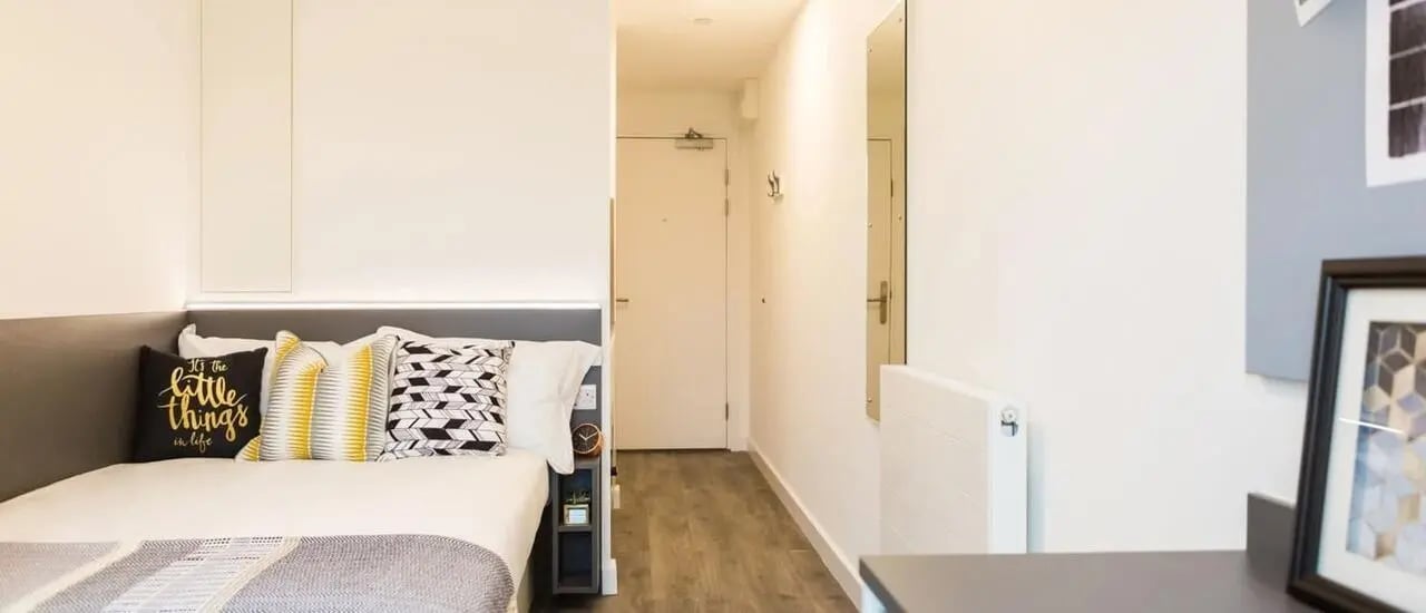 Bed with pillows door and radiator bedroom at Chapter White City in London Student Accommodation