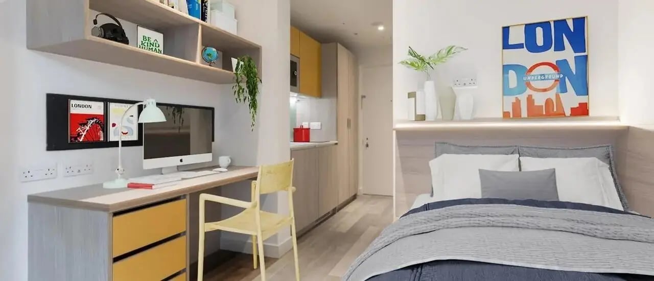 Desk computer chair bed and kitchen living room at Chapter London Bridge in London Student Accommodation