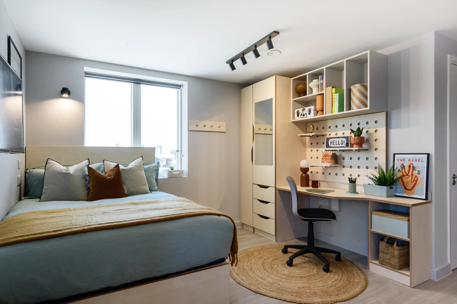 Bed desk wardrobe and shelving unit bedroom at Ironworks House in London Student Accommodation