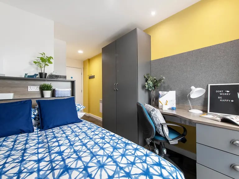 Bed with blue pillows desk with lamp bedroom at Yugo Bentley House in Birmingham Student Accommodation