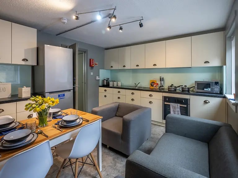 Dining table chairs sofa fridge kitchen area at Meadow Court in Edinburgh Student Accommodation
