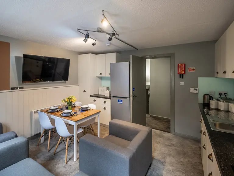 TV dining table chairs and kitchen living room at Meadow Court in Edinburgh Student Accommodation