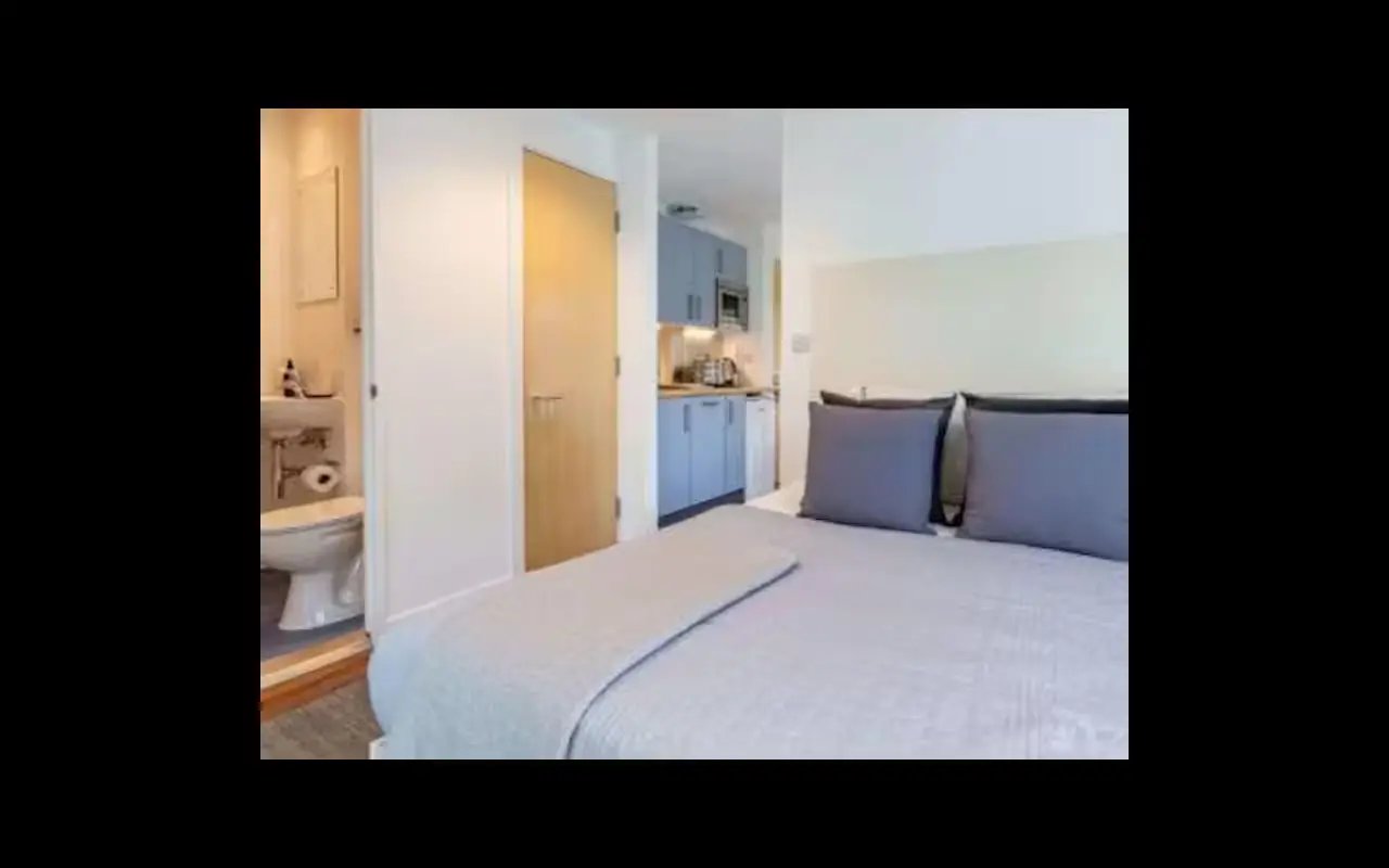 Bed pillows kitchen and bathroom student studio bedroom at Harbour Court in Bristol Student Accommodation