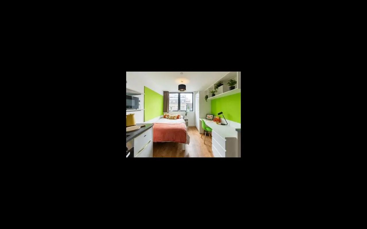Bed desk and kitchen area Student studio room at St Lawrence House in Bristol Student Accommodation