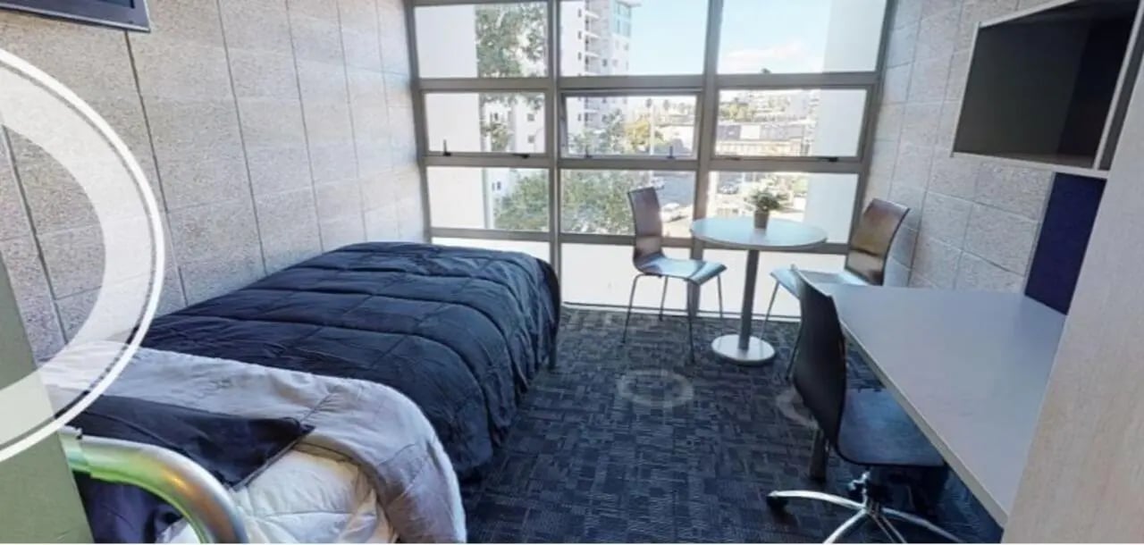Two beds desk table chairs and window bedroom at Student Living Auckland in Auckland Student Accommodation