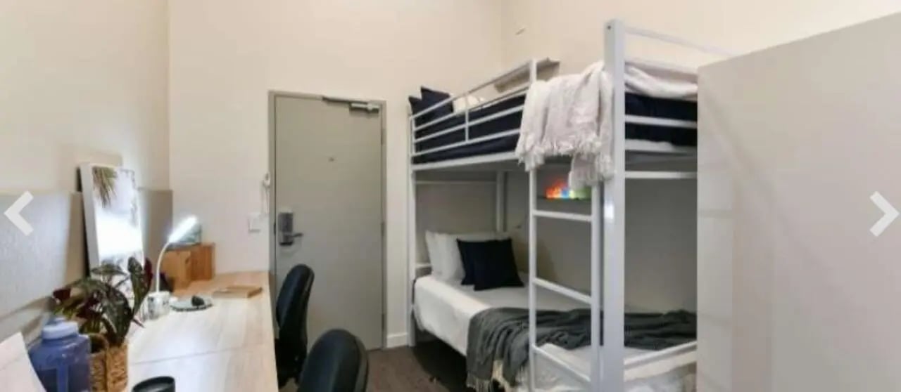 Bunk beds desk two chairs door bedroom at UniLodge Herston in Brisbane Student Accommodation