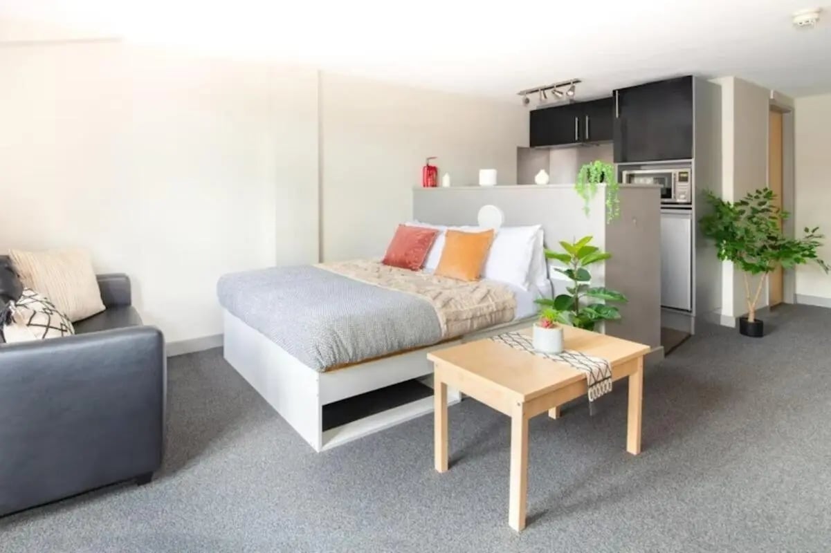 Bed sofa coffee table kitchen area living room at Studio 58 in Bristol Student Accommodation