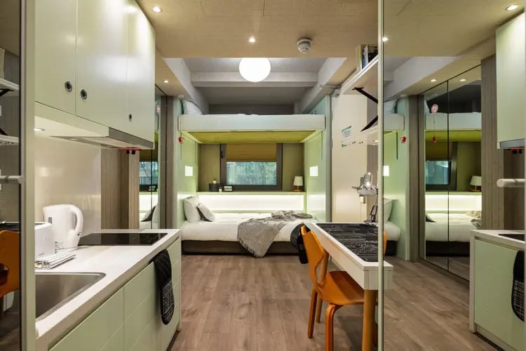 Bunk bed kitchen sink desk and chairs room at The Stay Club North Acton in London Student Accommodation