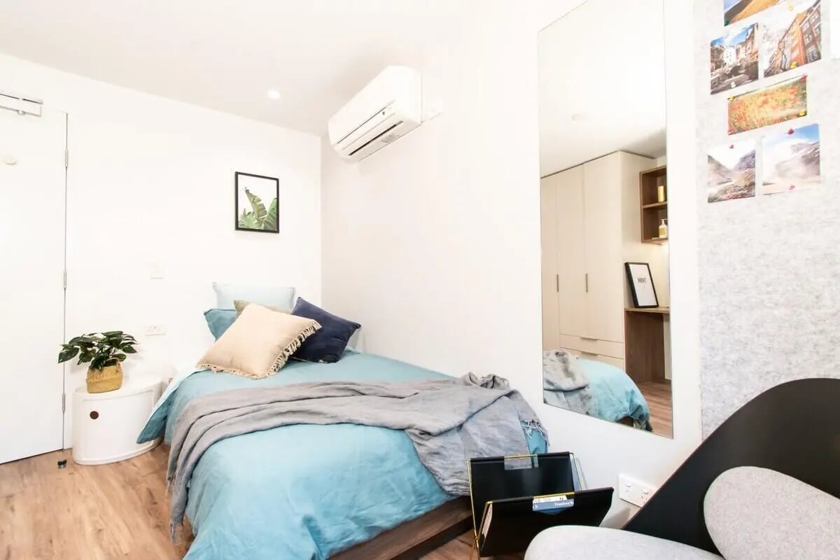 Bed with pillows blanket and air conditioner bedroom at UniLodge Park Avenue in Melbourne Student Accommodation