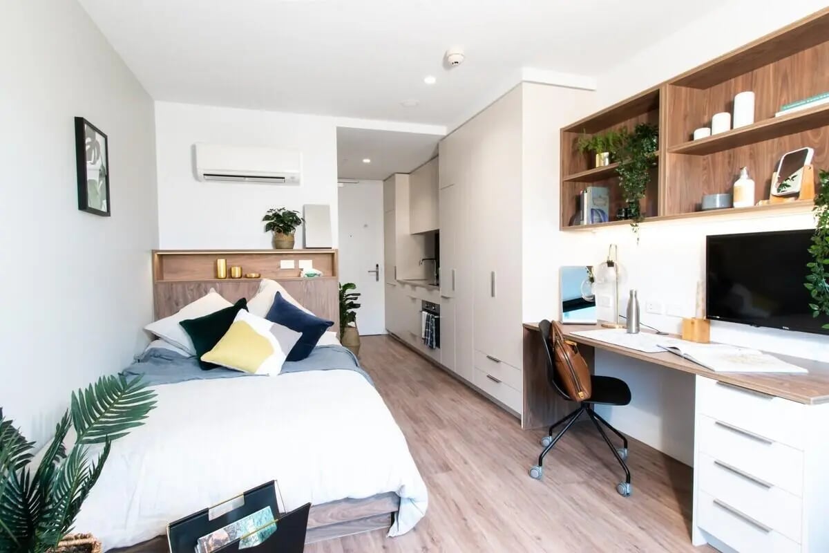 Bed desk air conditioner and kitchen studio apartment at UniLodge Park Avenue in Melbourne Student Accommodation