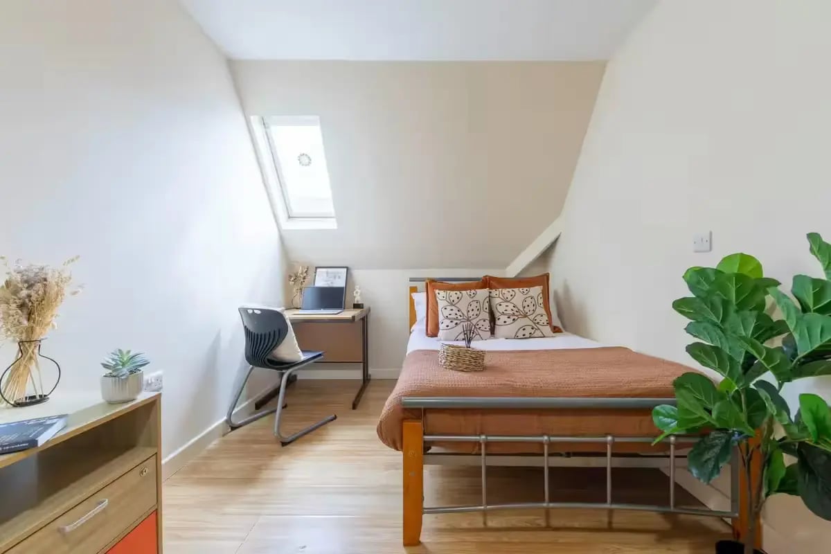 Bed desk chair pillows and plant bedroom at dwell Castle Gate Haus in Nottingham Student Accommodation