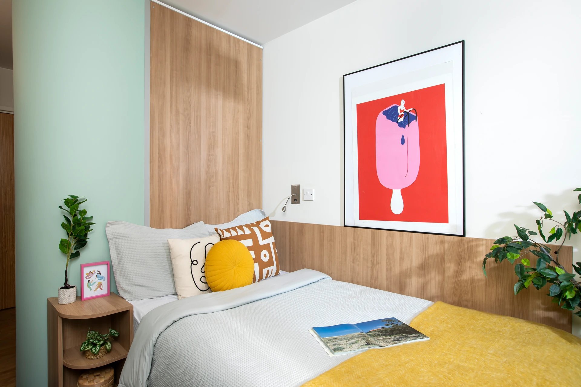 Bed with yellow throw and art bedroom at Dorset House in Oxford Student Accommodation
