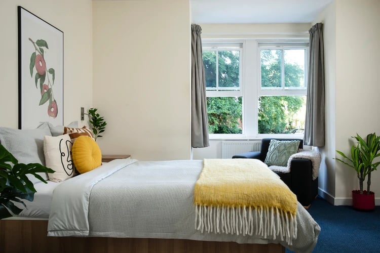 Bed with yellow throw armchair and window bedroom at Dorset House in Oxford Student Accommodation