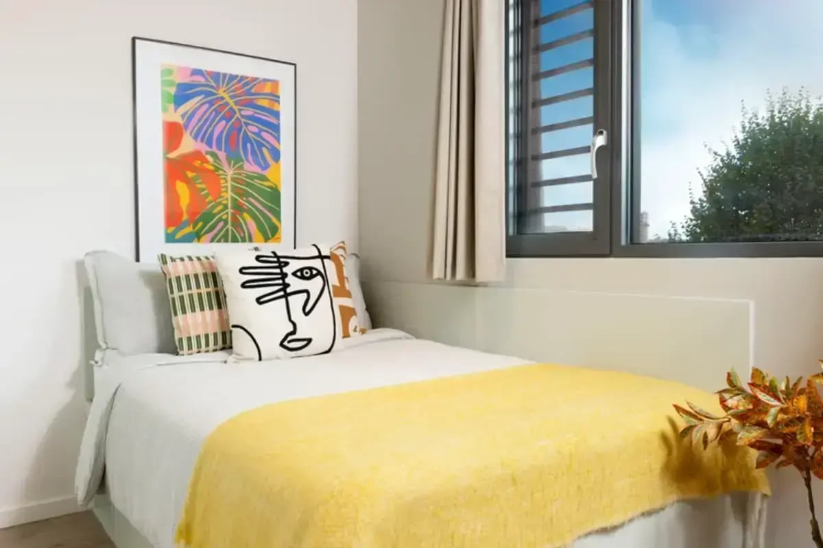 Bed with abstract art and yellow throw bedroom at Avon Point in Bristol Student Accommodation