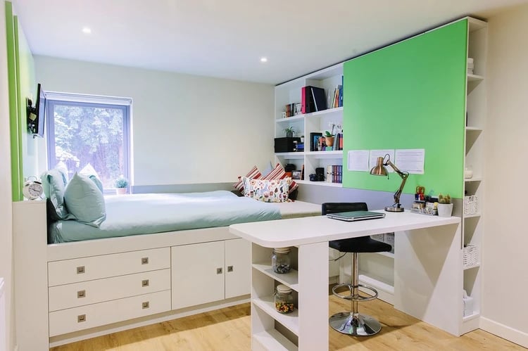 Bed with storage desk lamp shelves whiteboard study area at Cathedral Park in Bristol Student Accommodation