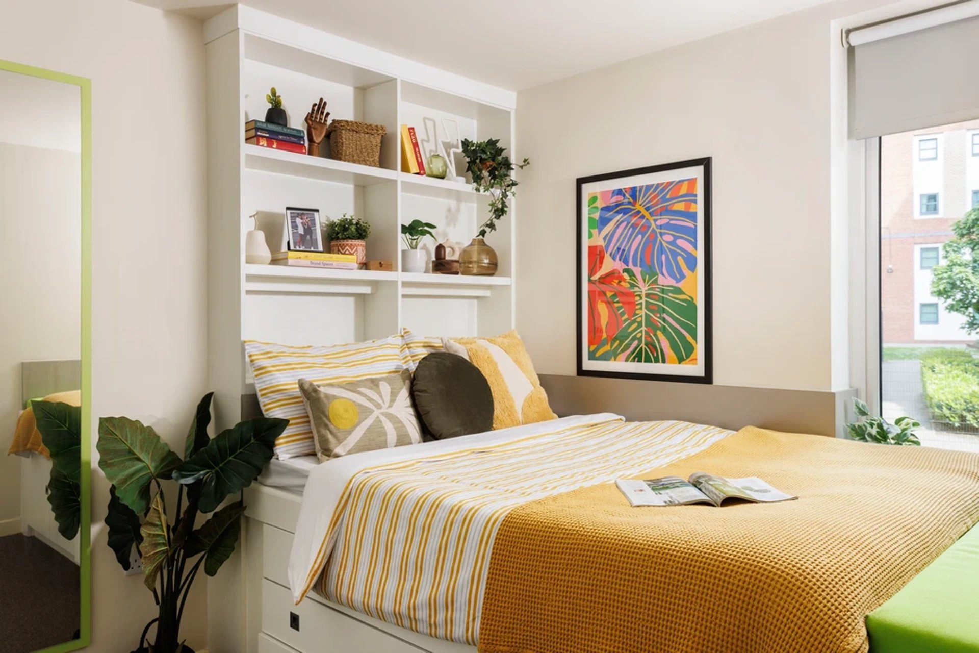 Bed with yellow bedding and shelves bedroom at Quay Point Studios in Newcastle Upon Tyne Student Accommodation