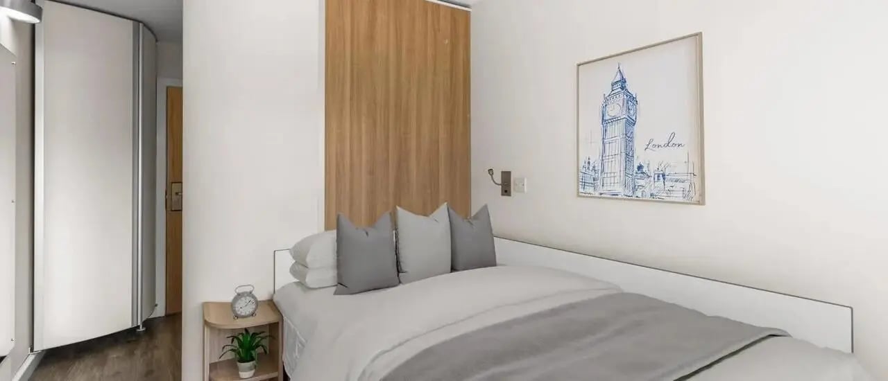 Bed with gray pillows and London art Bedroom at Chapter Islington in London Student Accommodation