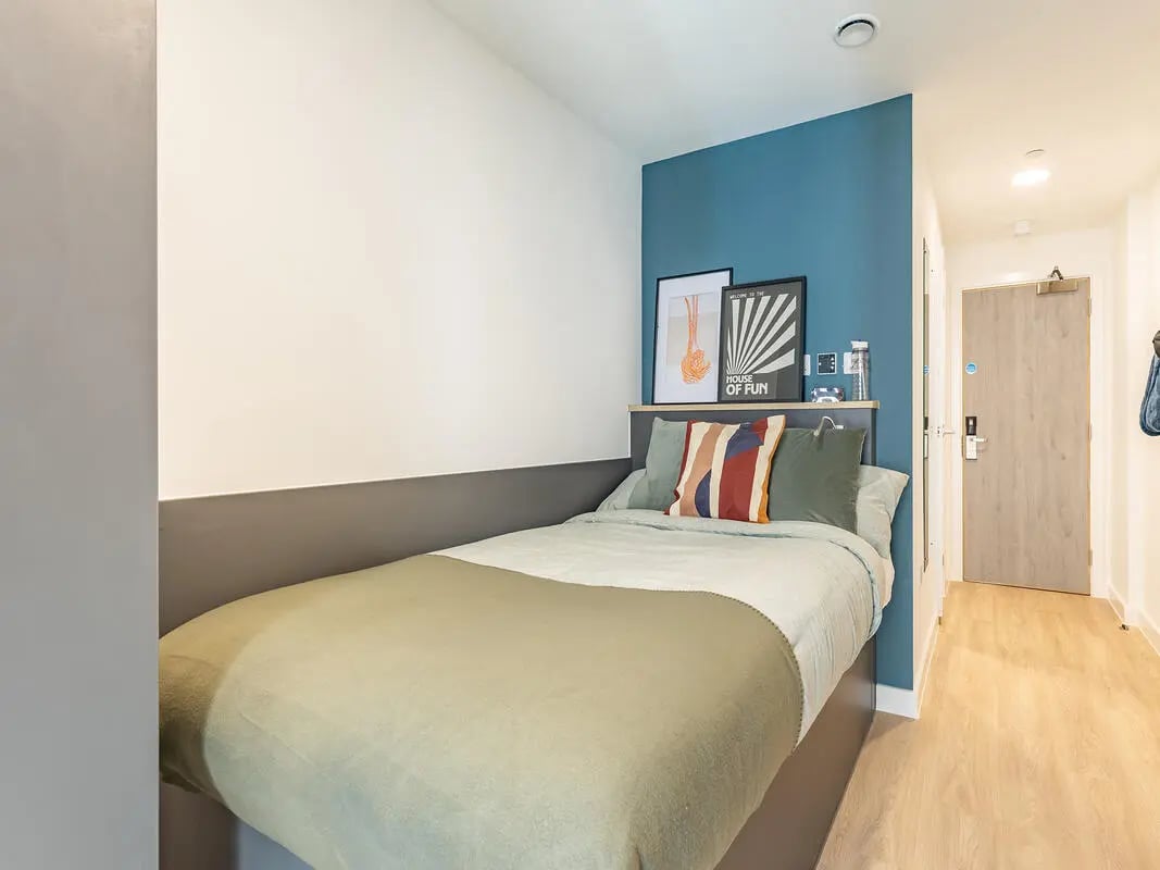 Bed with pillows artwork and door bedroom at Fabric in Nottingham Student Accommodation