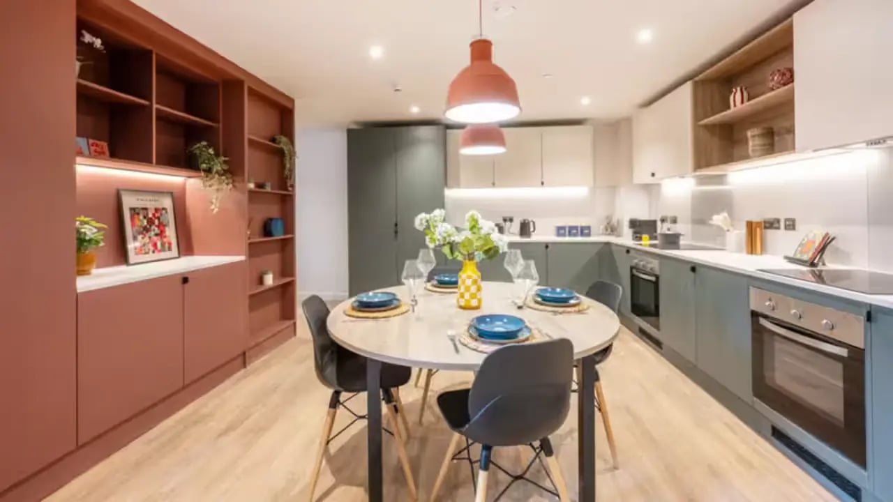 Dining table with place settings and kitchen area kitchen at Centre Court in Nottingham Student Accommodation