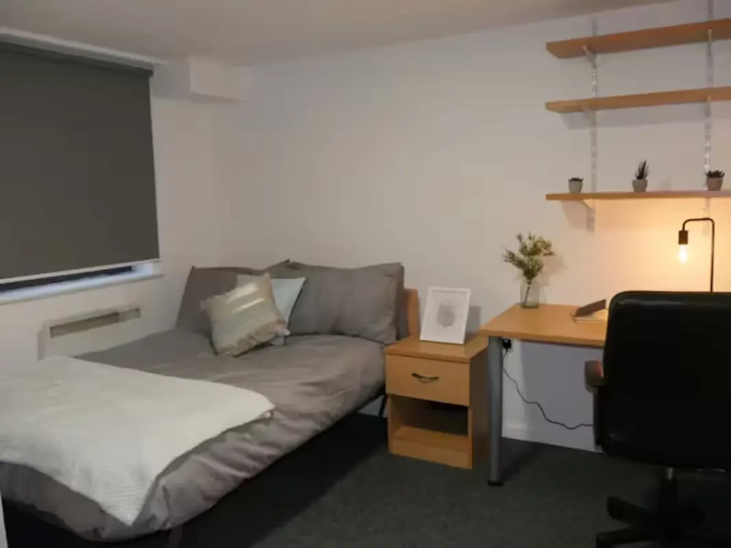 Bed with pillows and nightstand with framed art Bedroom at Central Place in Sheffield Student Accommodation