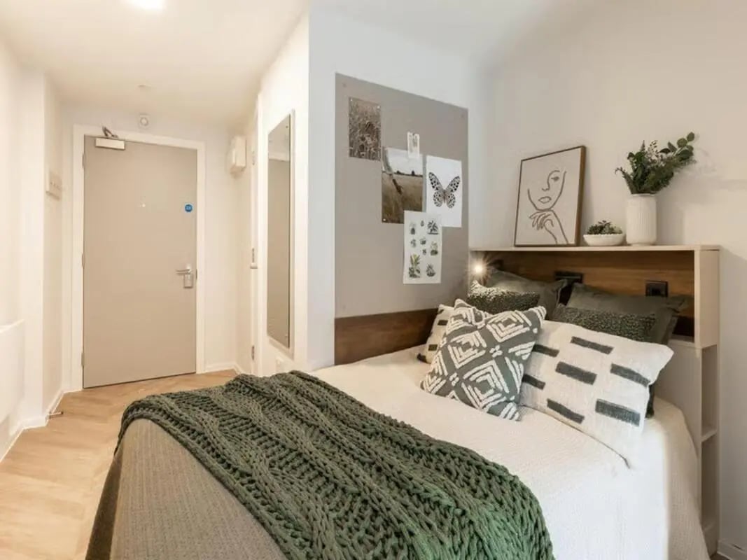 Bed with pillows and knitted throw bedroom at The Place in Nottingham Student Accommodation
