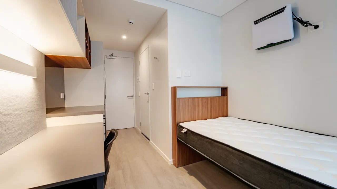 Bed desk door shelves and air conditioner bedroom at UniLodge Auckland Central in Auckland Student Accommodation