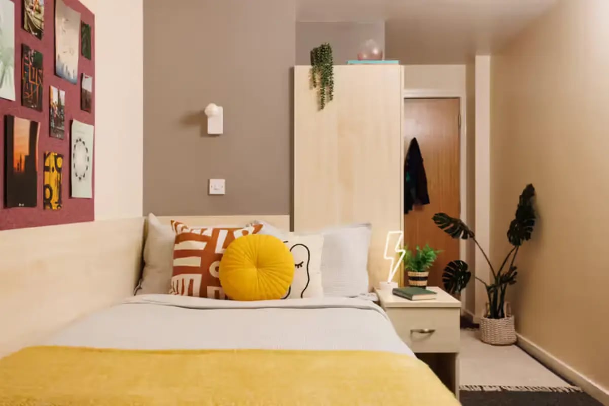 Bed with pillows and yellow blanket bedroom at The Tannery Leeds in Leeds Student Accommodation