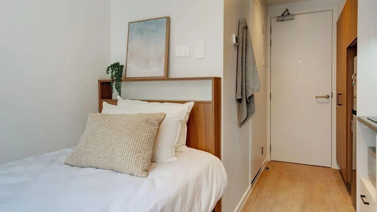 Bed with white linens and textured pillow Bedroom at UniLodge Auckland Central in Auckland Student Accommodation