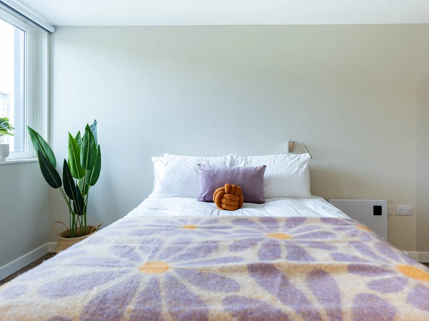 Bed with floral throw and plant bedroom at Stanley Studios - Dundee in Dundee Student Accommodation