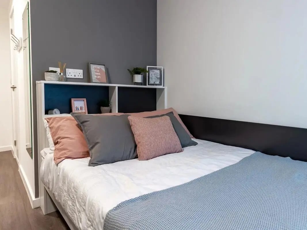 Bed with pillows shelf and decor bedroom at Pavilion Court London in London Student Accommodation