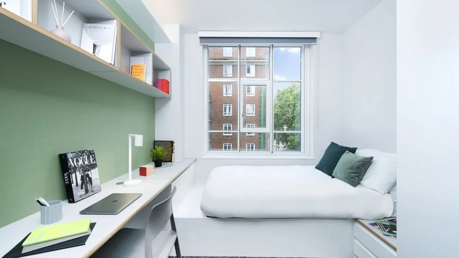 Bed and desk with laptop and books bedroom at Scape Bloomsbury in London Student Accommodation