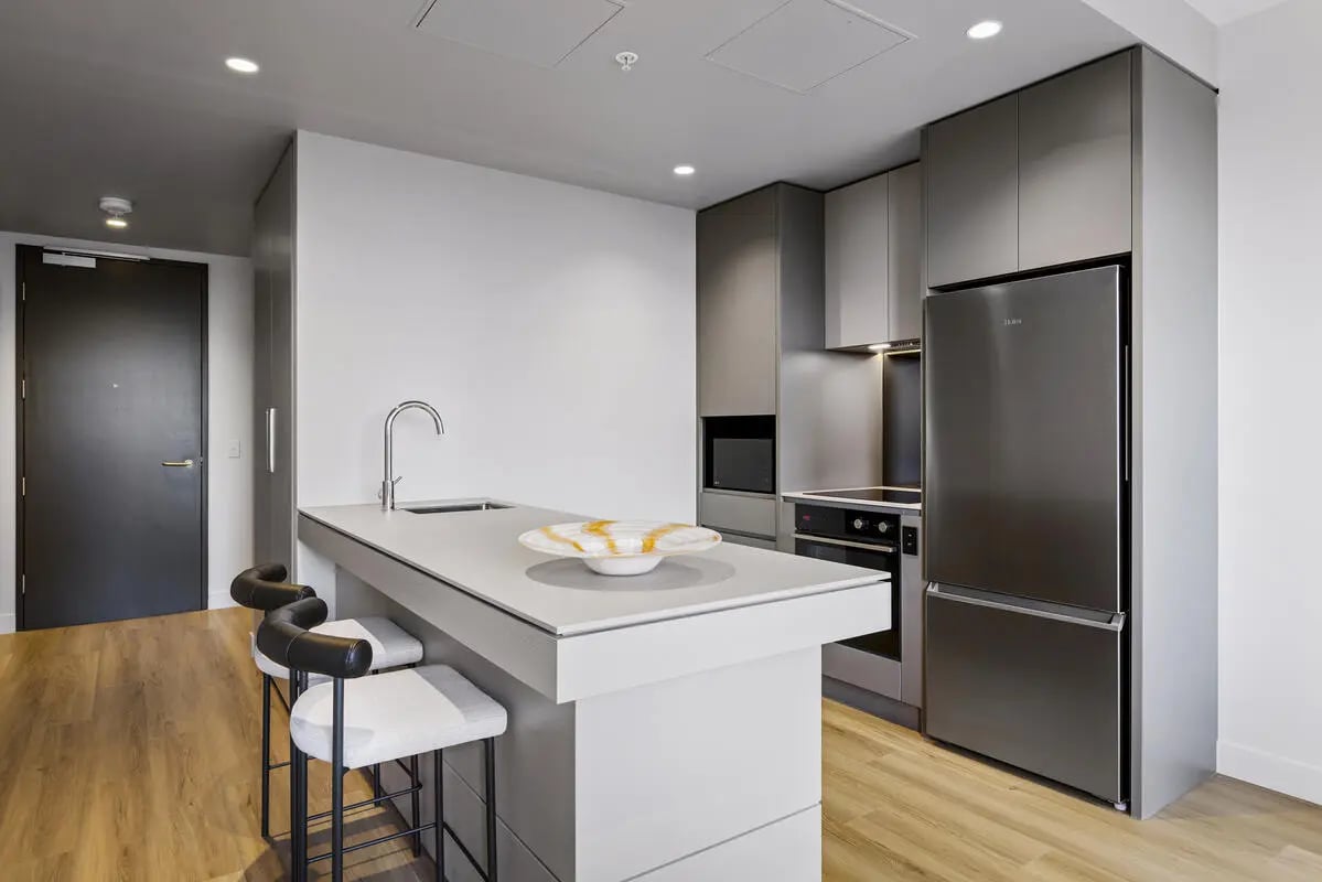 Kitchen island with bar stools stainless steel appliances kitchen at Indi South Bank in Melbourne Student Accommodation