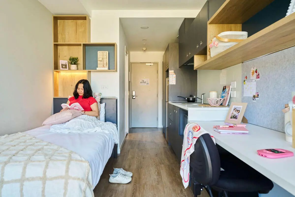 Bed, kitchen counter, desk, and chair living room at UniLodge Royal Melbourne in Melbourne Student Accommodation