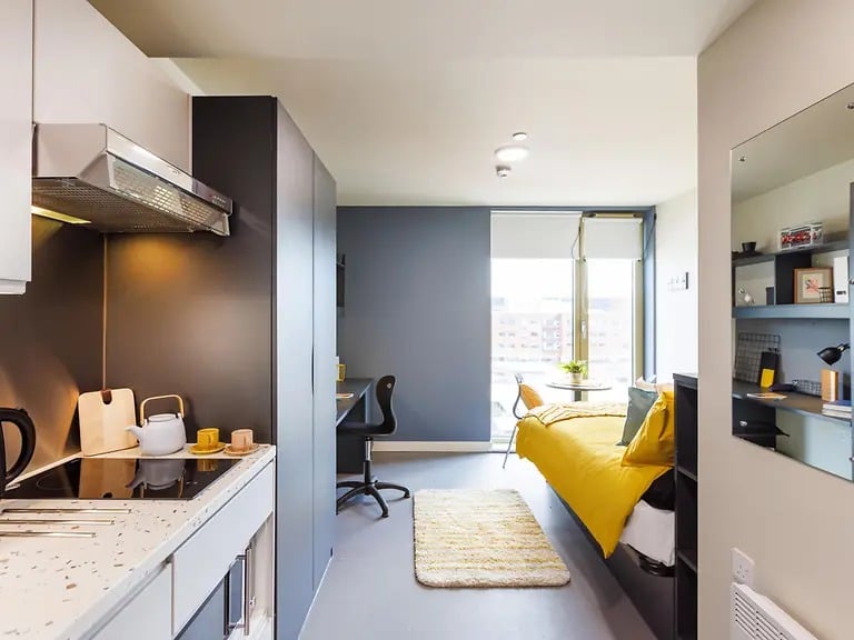 Kitchen and bedroom with bed and desk Studio apartment at Element Manchester in Manchester Student Accommodation