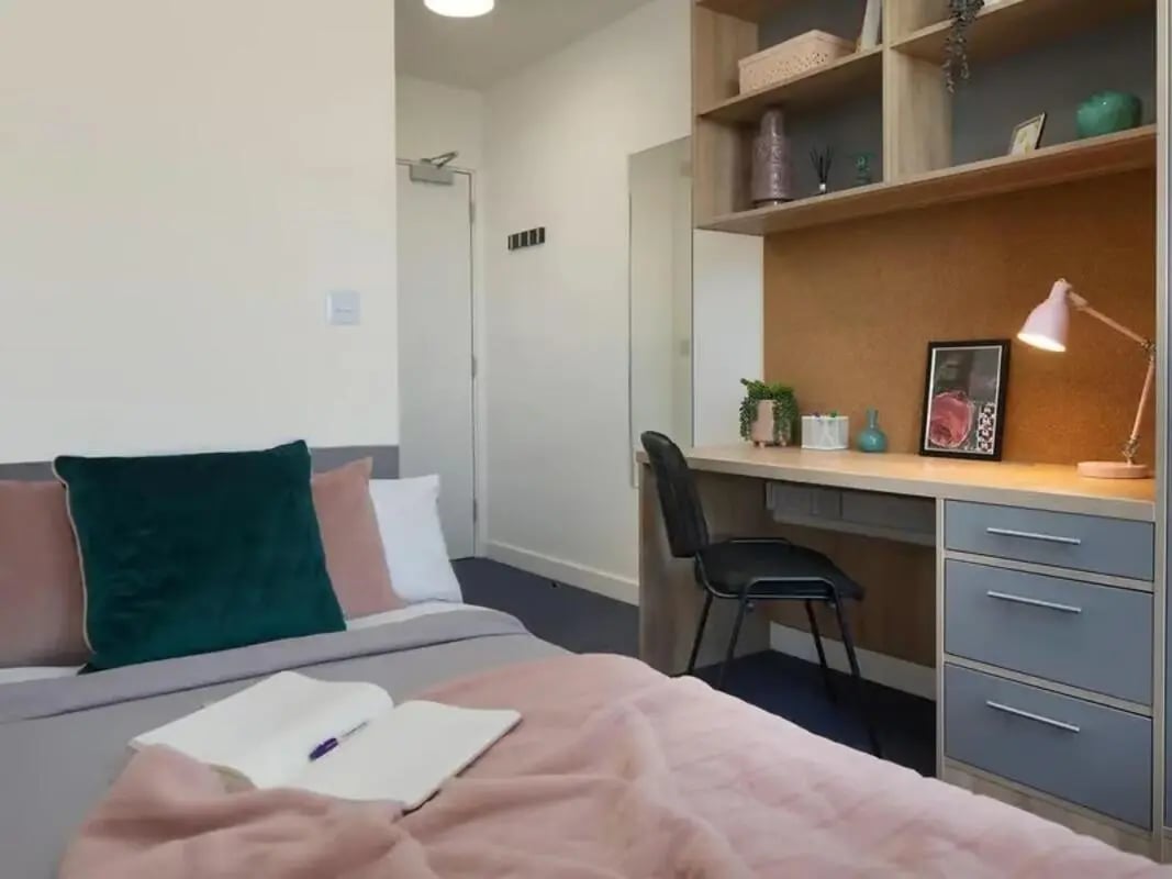 Bed pillows desk chair and lamp bedroom study area at Globe Works in Birmingham Student Accommodation