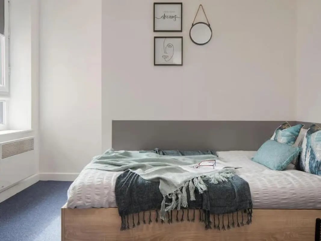 Bed with blue throws and pillows bedroom at Globe Works in Birmingham Student Accommodation