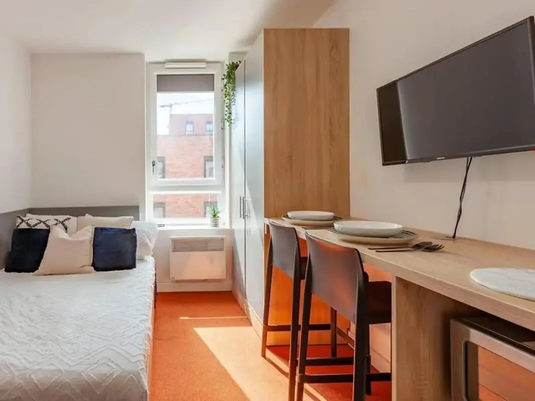 Bed counter with plates and chairs bedroom at Globe Works in Birmingham Student Accommodation