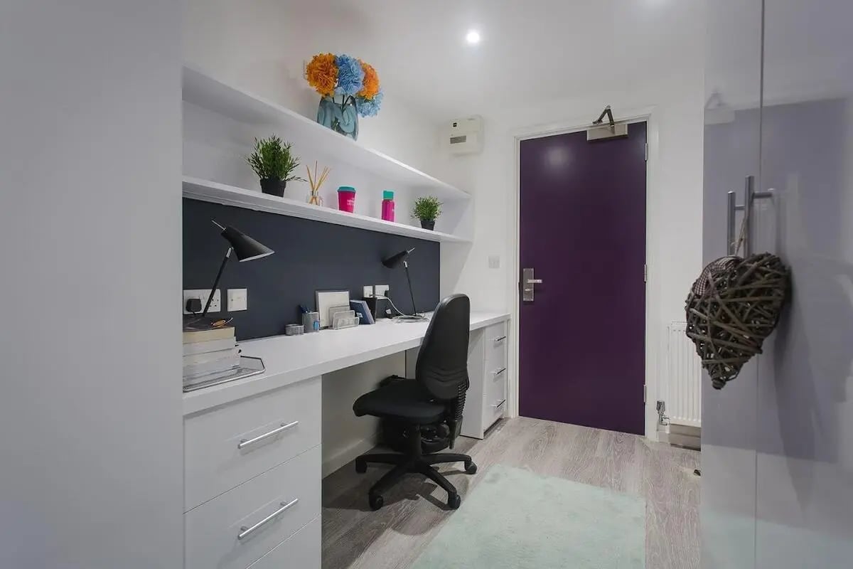 Desk lamps chair plants and purple door study area at The Cube Ealing in London Student Accommodation