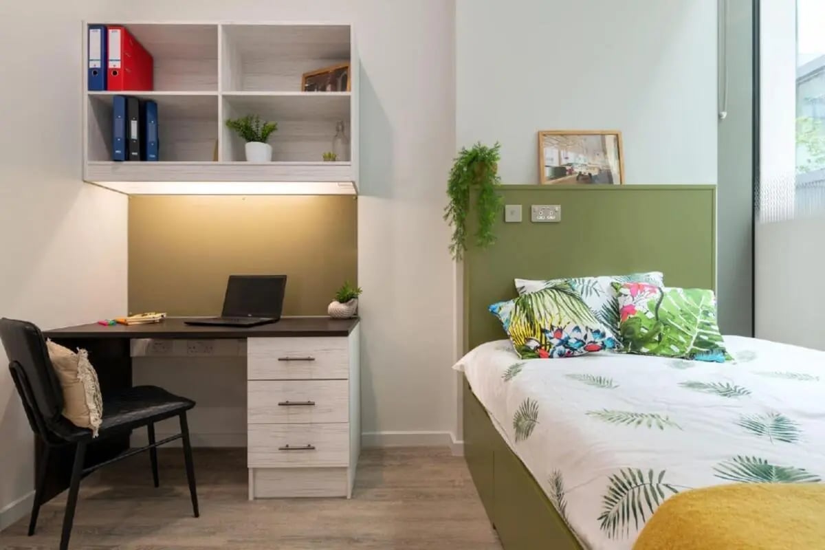 Desk shelf laptop and bed bedroom at Flora Building - Hoxton in London Student Accommodation