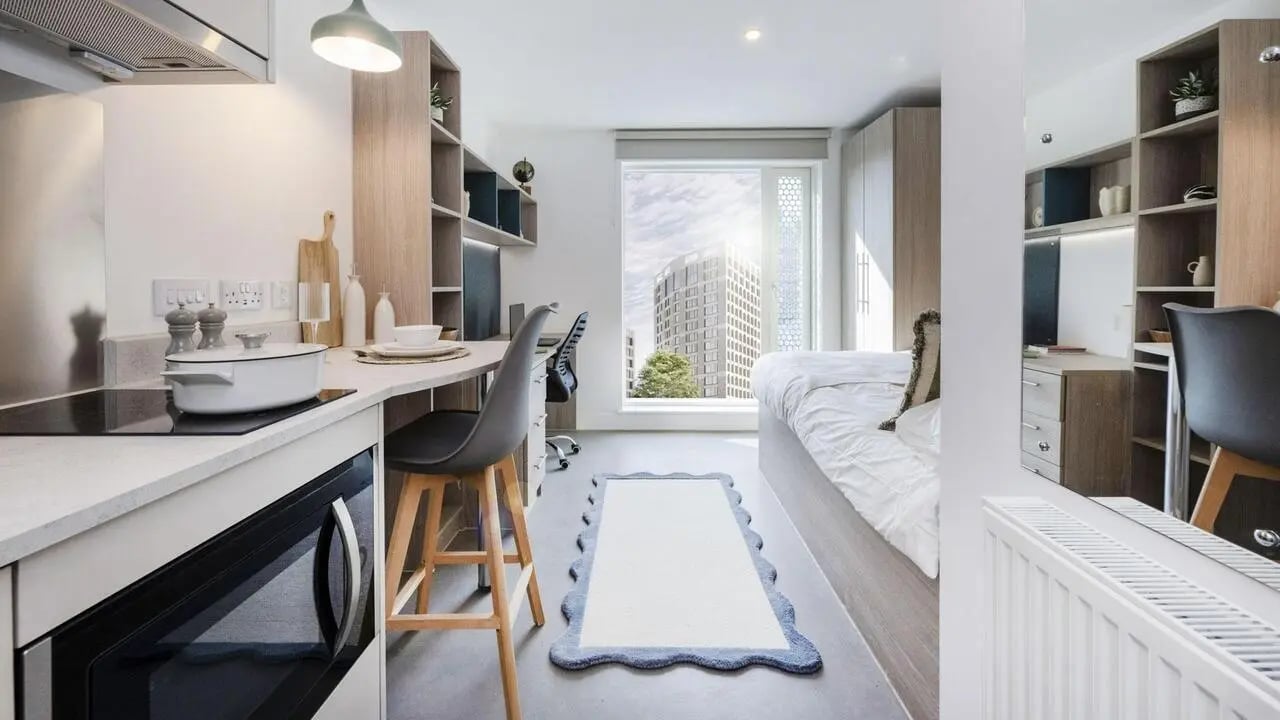 Bed desk kitchen shelves and radiator studio apartment at Timber Yard in Bristol Student Accommodation