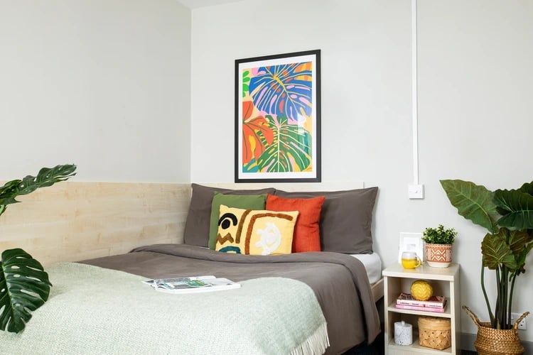 Bed with colorful pillows and bedside table bedroom at Blackfriars in Glasgow Student Accommodation