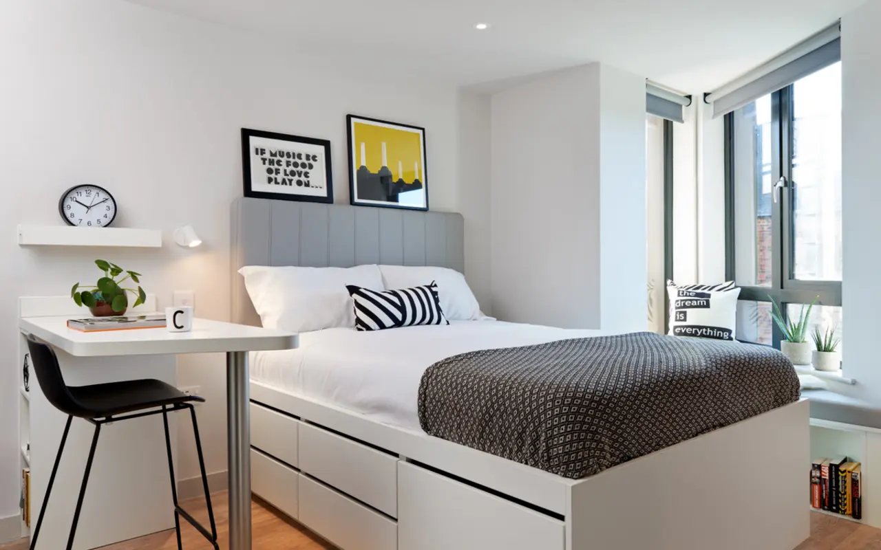 Bed with drawers desk plant clock artwork bedroom at Student Castle Durham in Durham Student Accommodation
